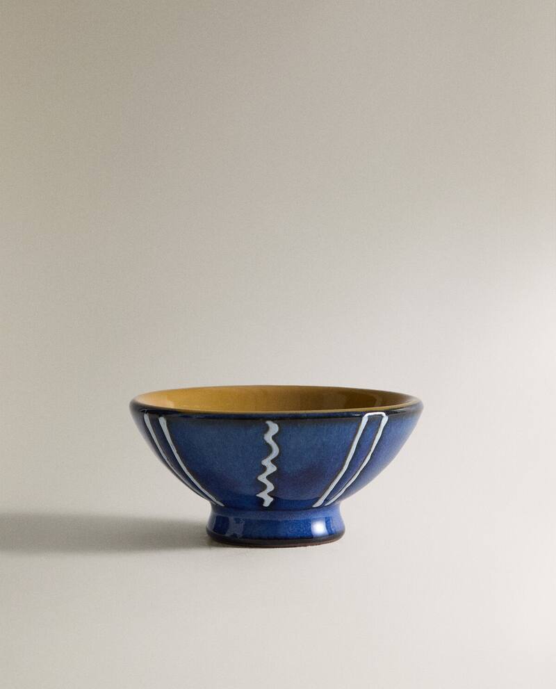 Medium shot of a blue ceramic bowl with white stripe