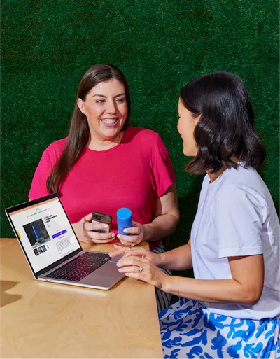 Two happy women working on a laptop