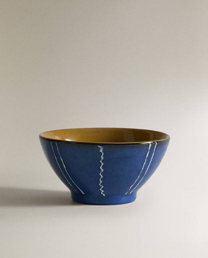 Closeup of a blue ceramic bowl with white stripes