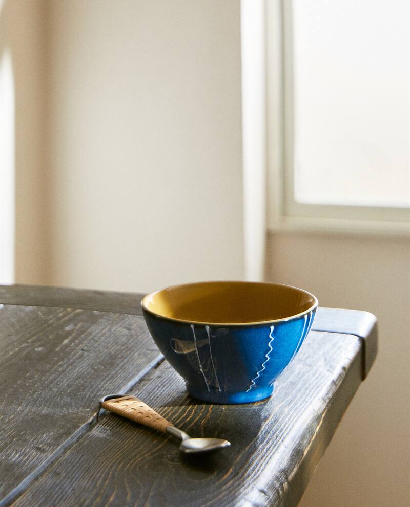 Blue ceramic bowl with white stripe on a table