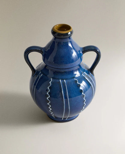 Closeup of a blue ceramic vase with white stripes