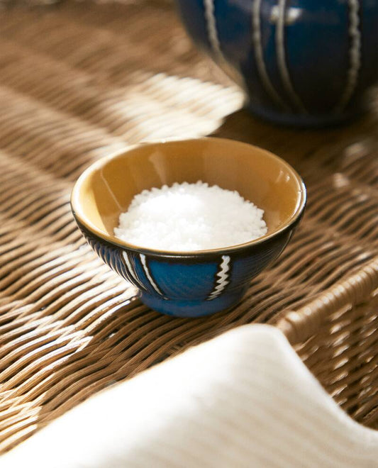 Blue ceramic bowl with white stripes with salt