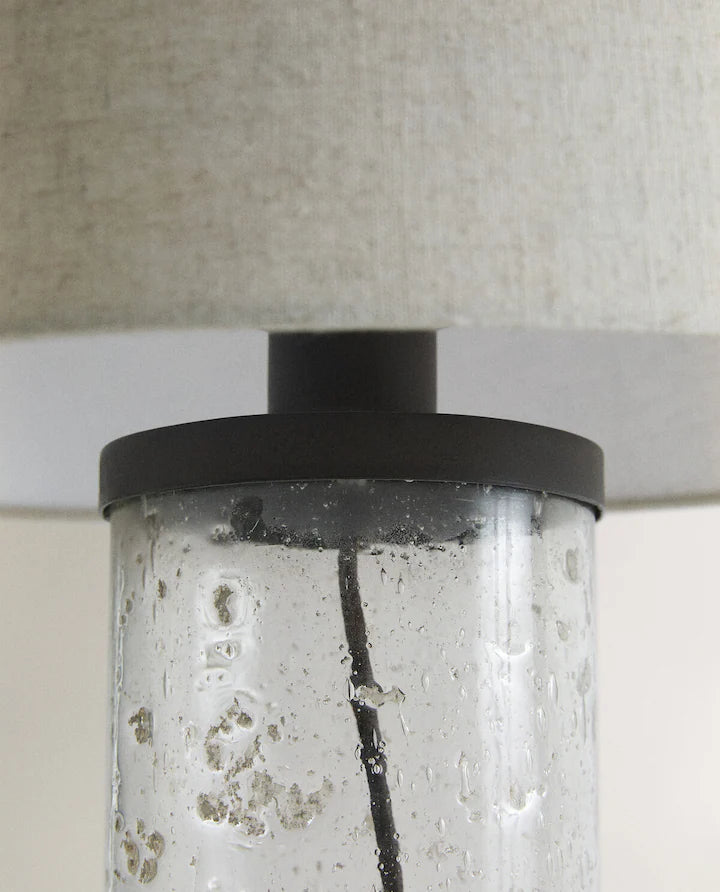 Closeup of the middle part of a lamp with glass base