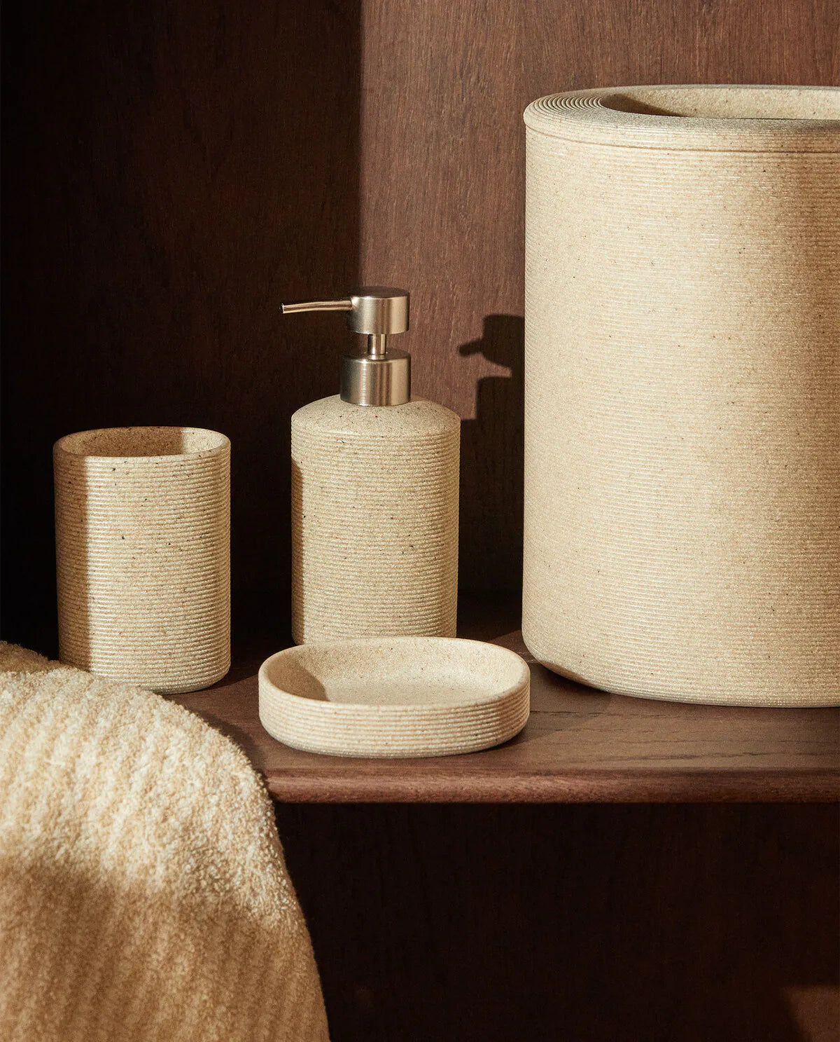 Beige ceramic bathroom accesories on a shelf